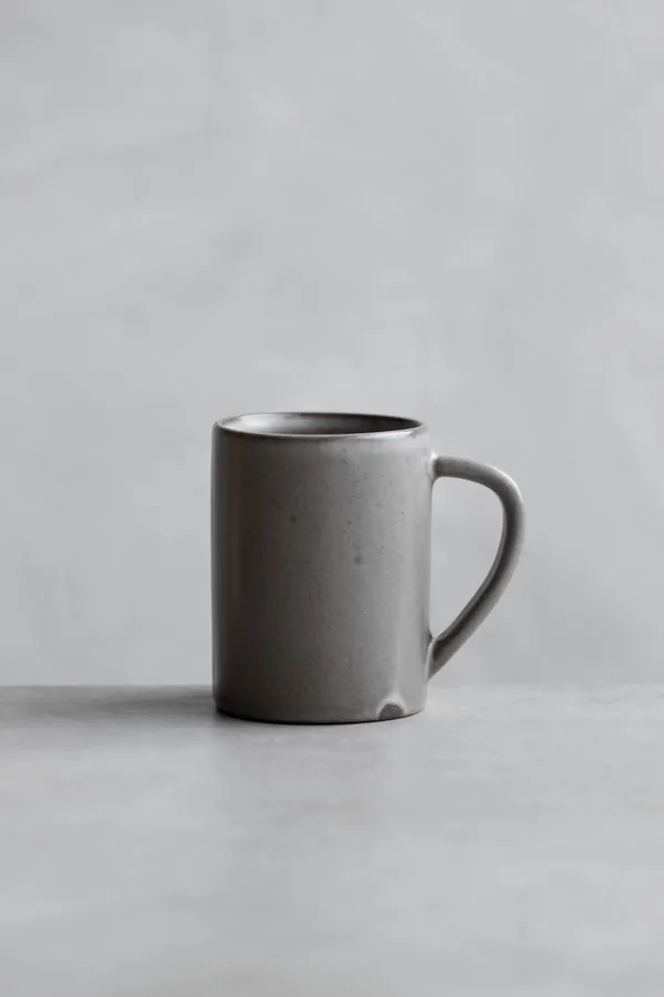A minimalist gray stoneware mug on concrete