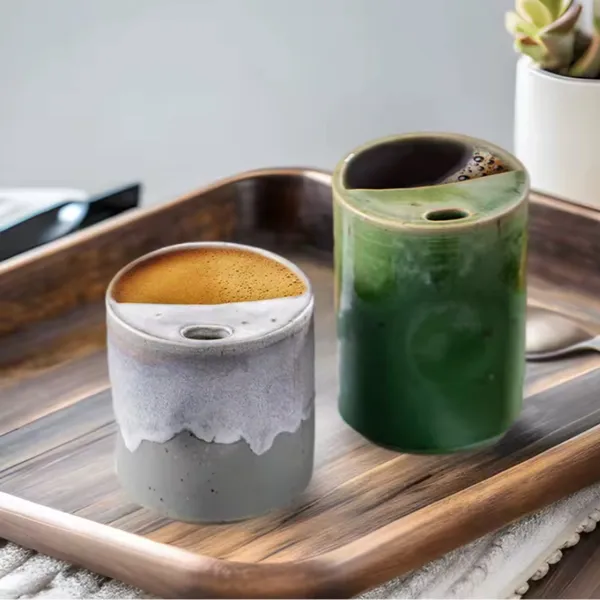 Two stoneware mugs with coffee on a wooden tray